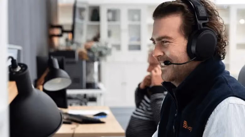 Customer service team member wearing a headset, assisting with car sale enquiries at 1800 Salvage.