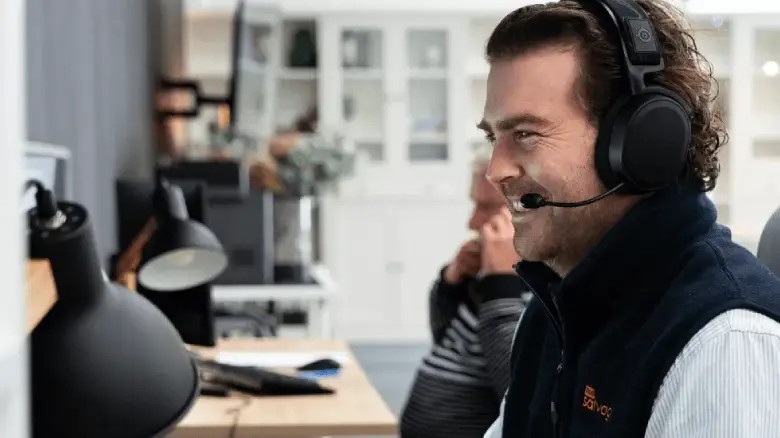 Customer service team member wearing a headset, assisting with car sale enquiries at 1800 Salvage.