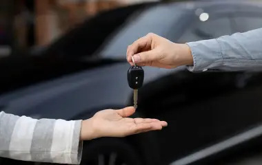 Person handing over car keys in Darwin, showing the process to sell your car quickly through a hassle free car buying service.