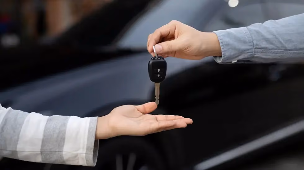 Person handing over car keys in Darwin, showing the process to sell your car quickly through a hassle free car buying service.