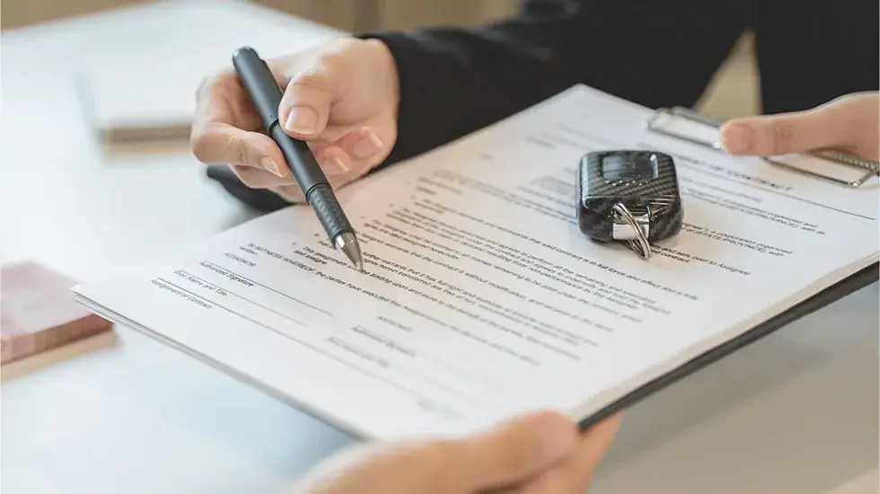 Person signing paperwork with car keys on top of the document, transferring ownership when selling an unregistered car in Hobart.