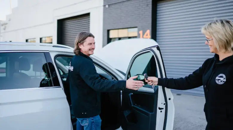 Customer handing car keys to 1800 Salvage team when selling a damaged car in Hobart.