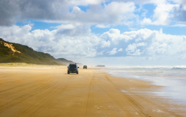 4WD’s driving down the beach in summer.