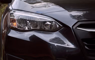 Front lights of a dark grey Subaru