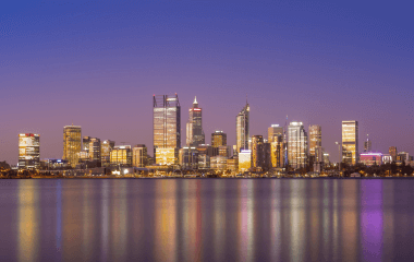 The Perth skyline at a purple-hued sunset.
