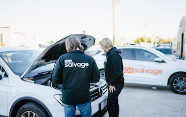 Salvage experts looking under a bonnet to see if the car engine is seized 