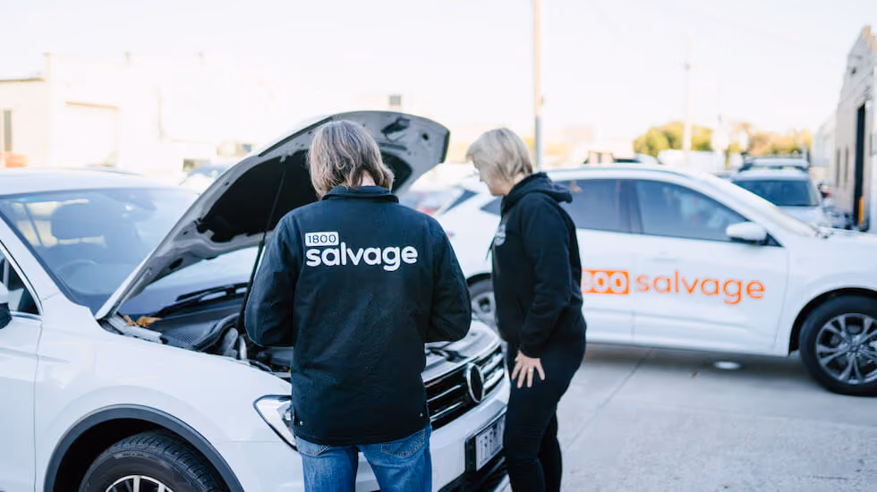 Salvage experts looking under a bonnet to see if the car engine is seized 