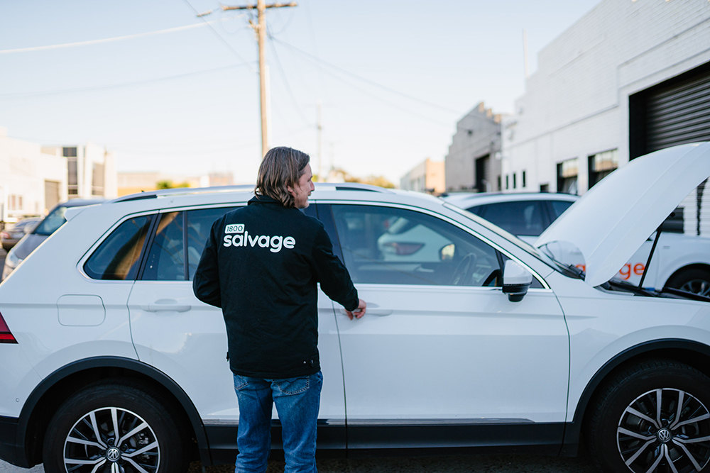 1800 Salvage team member inspecting a well-maintained SUV for valuation.