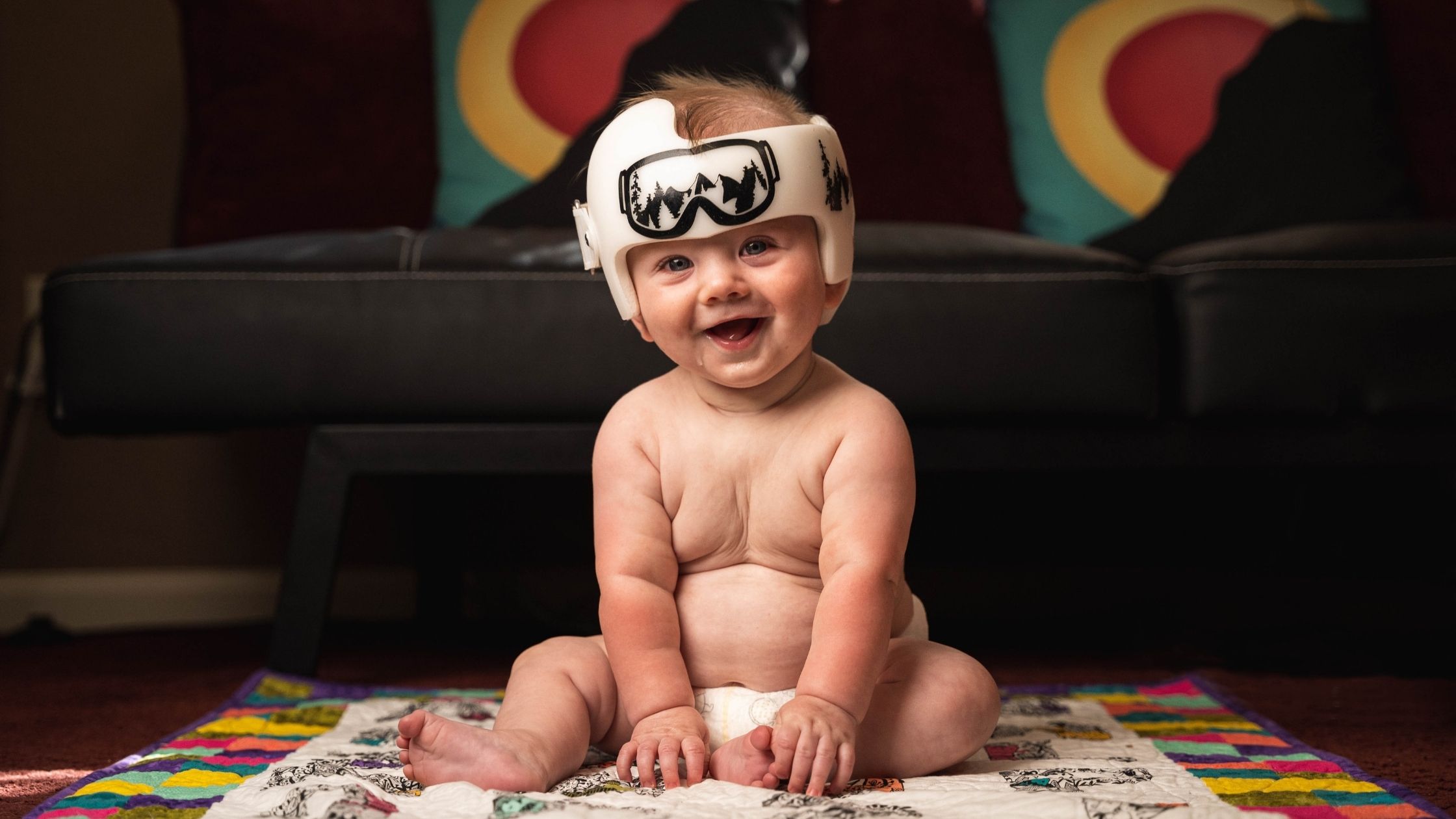 A Smiling Baby With A Helmet