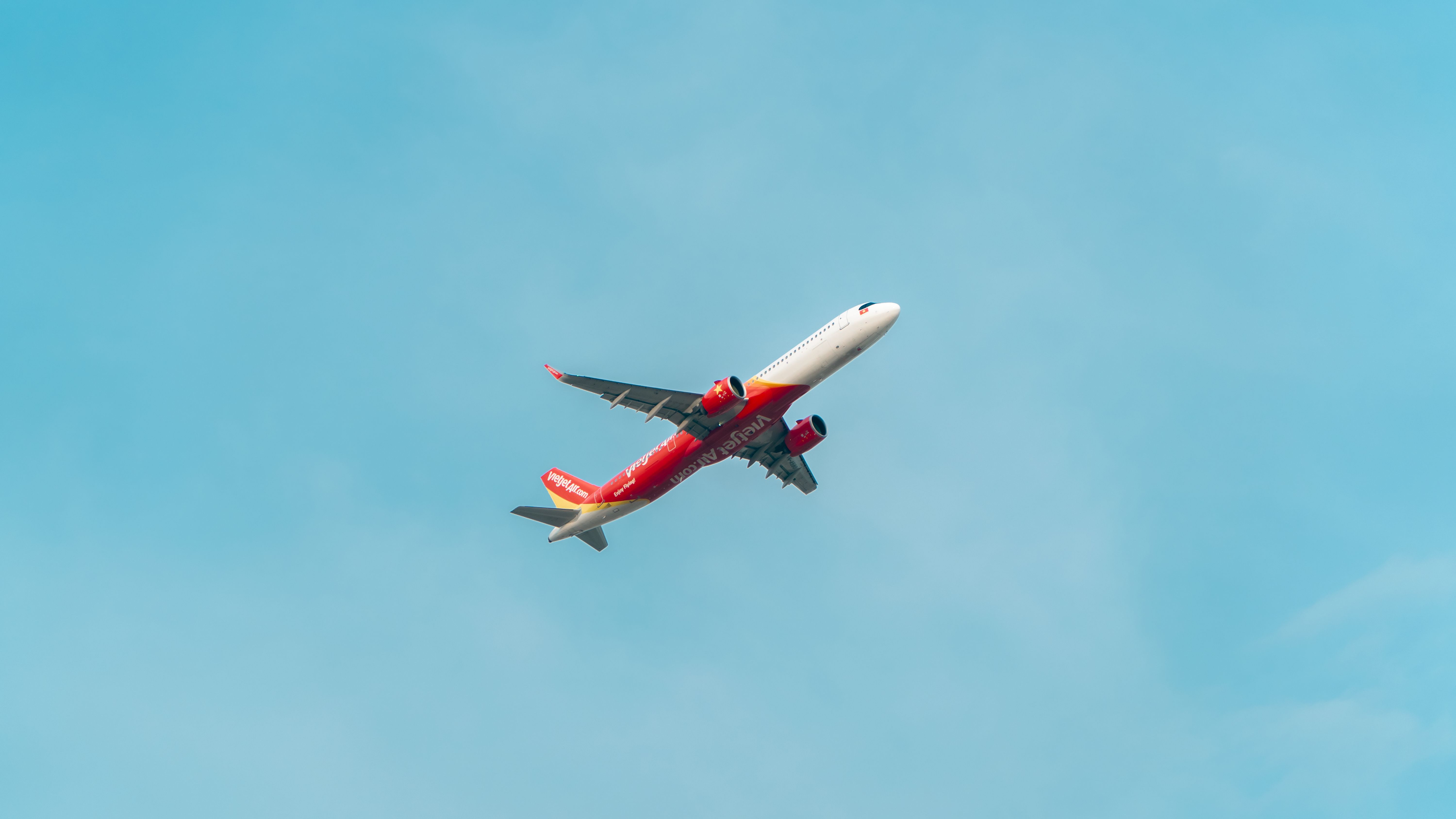 White plane in blue sky photographed from under.