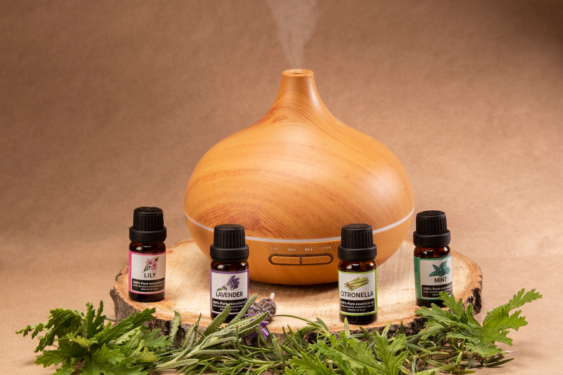 Wooden essential oil diffuser with 4 essential oils displayed in front on neutral background.f