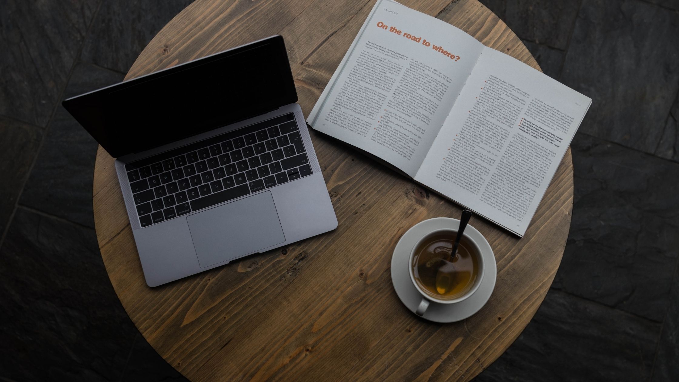 A laptop, a book; a cup of tea