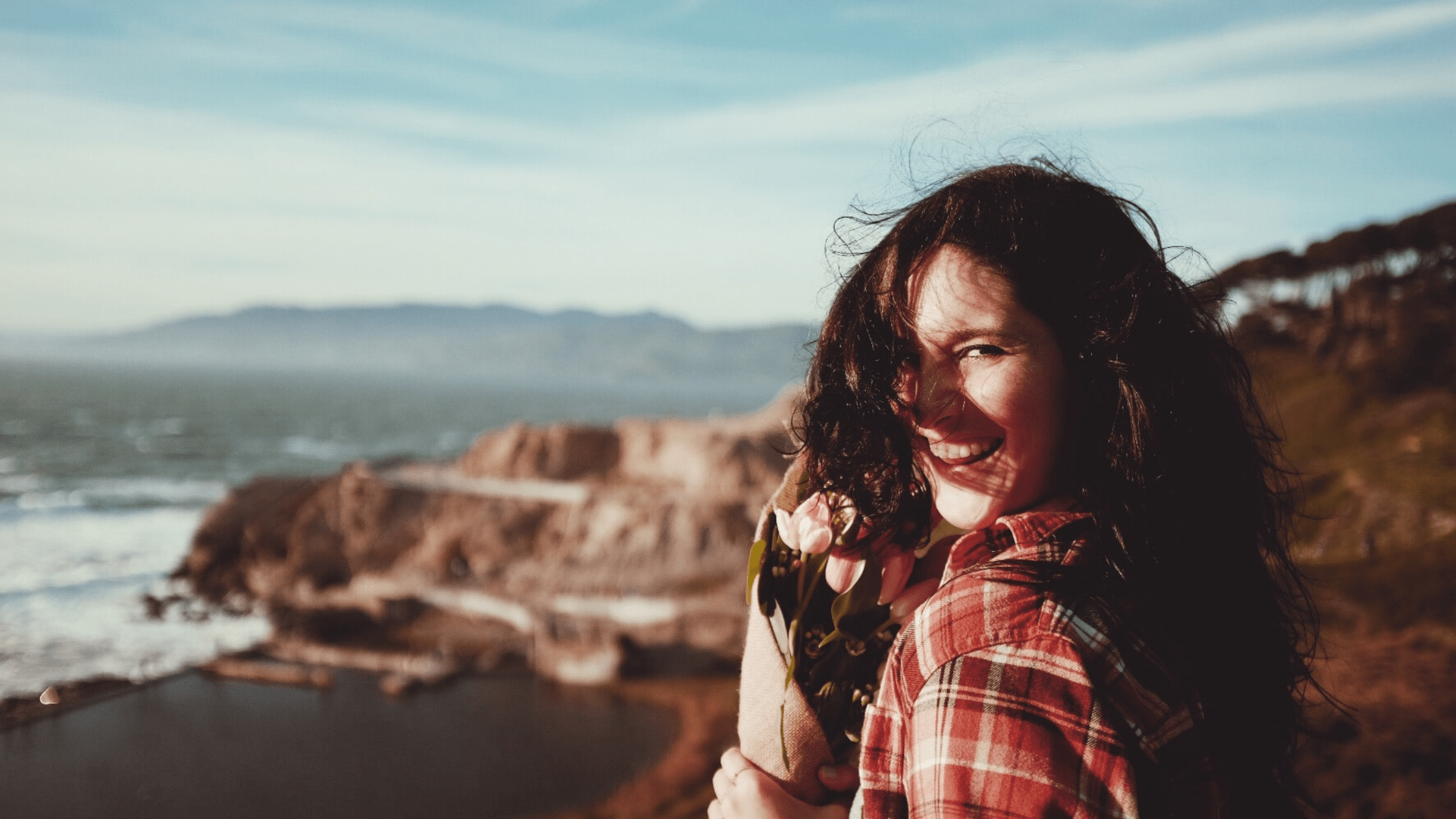 A woman smiling while holding some flowers