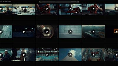 Raster aus verschiedenen Video-Vorschaubildern mit Wiedergabesymbolen, die verschiedene Szenen zeigen, darunter Menschen, Maschinen und Außenaufnahmen.