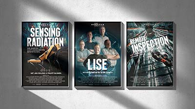 Drei beleuchtete Plakate im Kino-Stil an einer Wand mit den Titeln „Sensing Radiation“, „LISE“ und „Remote Inspection“, die sich mit wissenschaftlichen und technologischen Themen befassen.