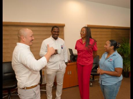 CEO of CB Group, Matthew Lyn (left) has the attention of Owen Hill, CEO of the Professional Football Jamaica Ltd (second left), Janet Sylvester, divisional manager, CB Foods Ltd (second right), and Samantha Fisher, assistant brand manager, CB Chicken, sho