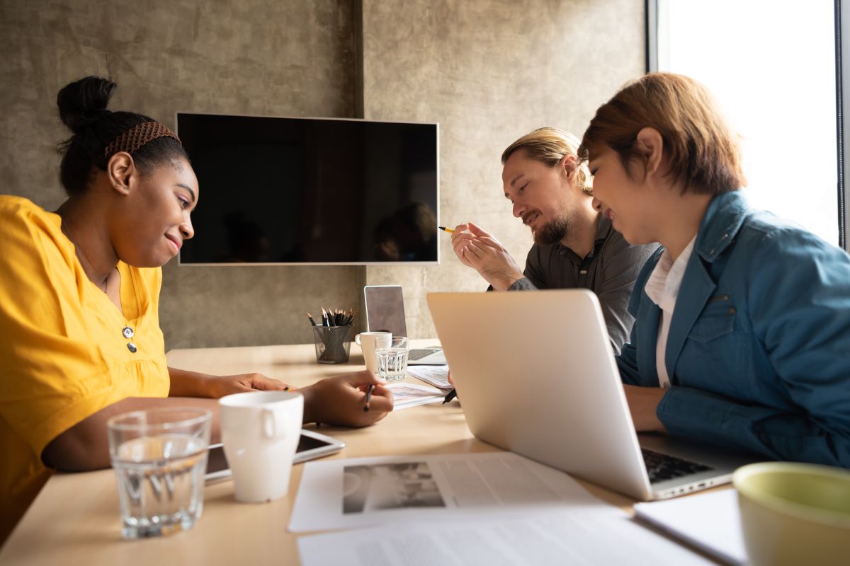 Group of 3 diverse colleagues working together in a conference room