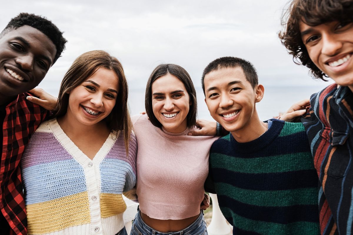 Portrait of multiracial friends having fun smiling on camera outdoor
