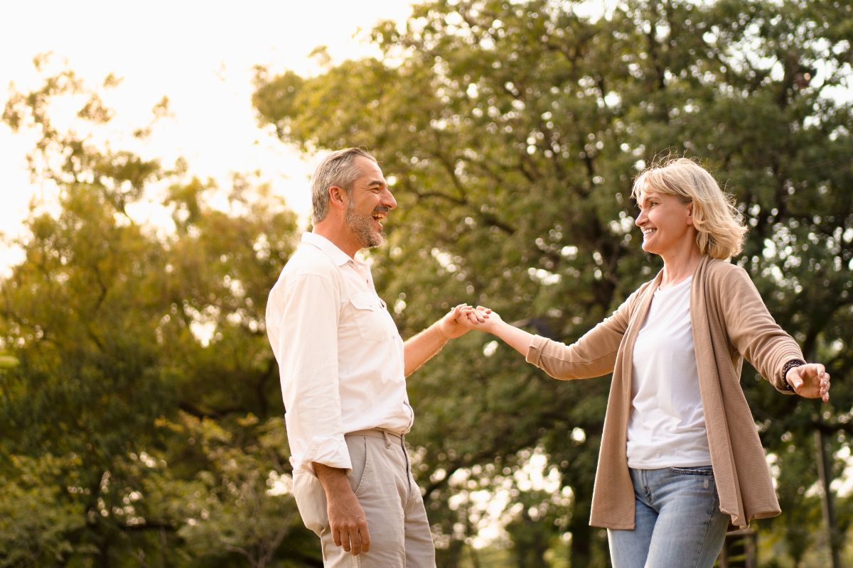 Senior caucasian couple dancing looking at each other feeling love and cherishing each other in the park