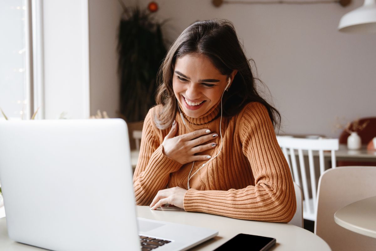 Young adult woman talking a video call on her laptop working from home