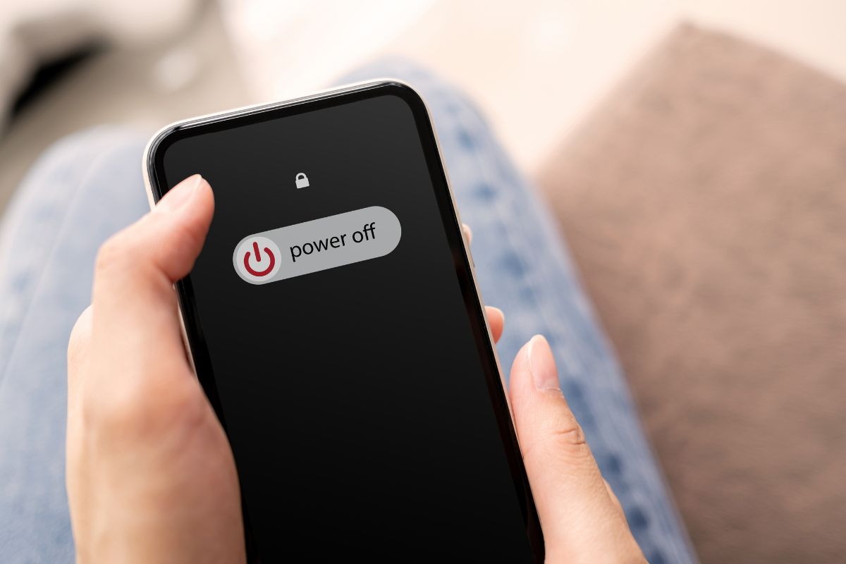 Iphone screen in a person's hand being powered off