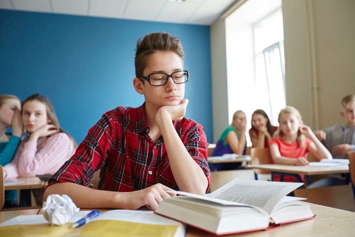 students gossiping behind classmate back at school