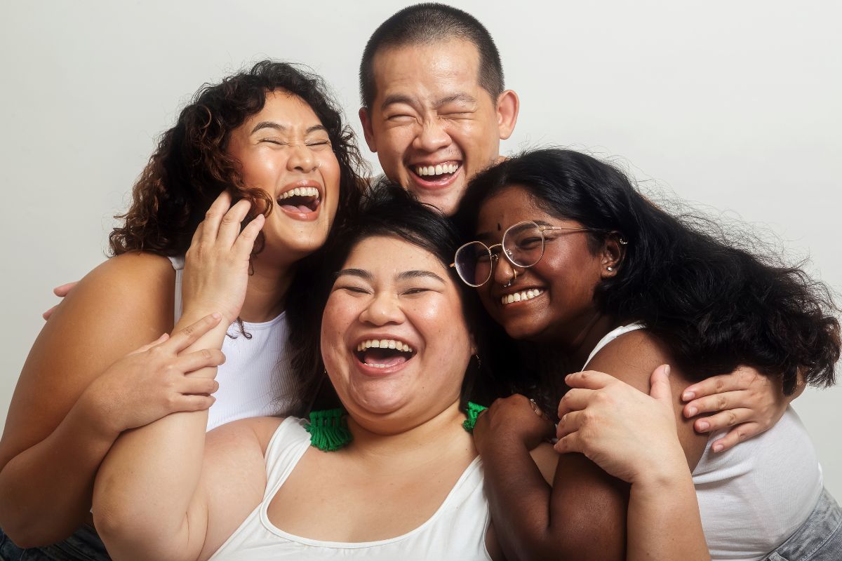 Group of 4 Asian friends of different body sizes happy, smiling, and laughing.