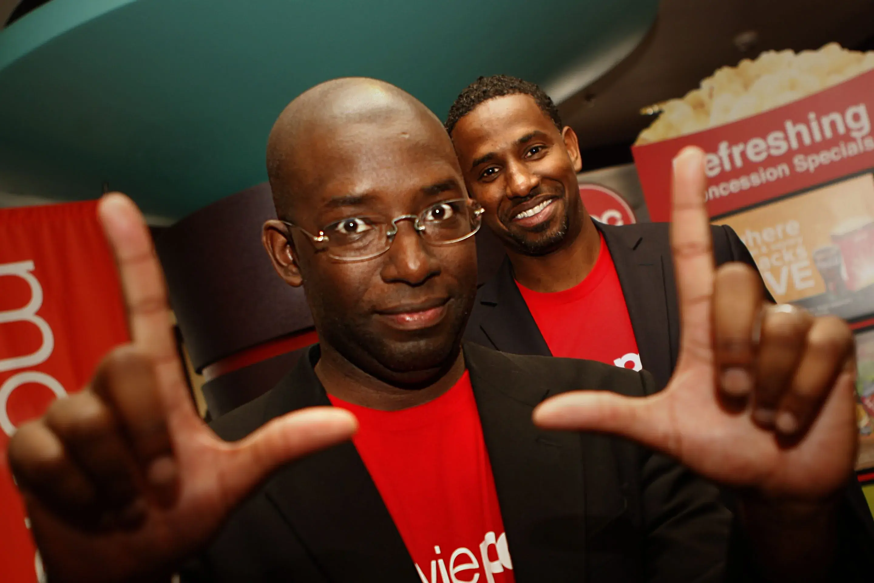 Stacy Spikes, MoviePass' CEO at a movie theater making the gesture of a frame