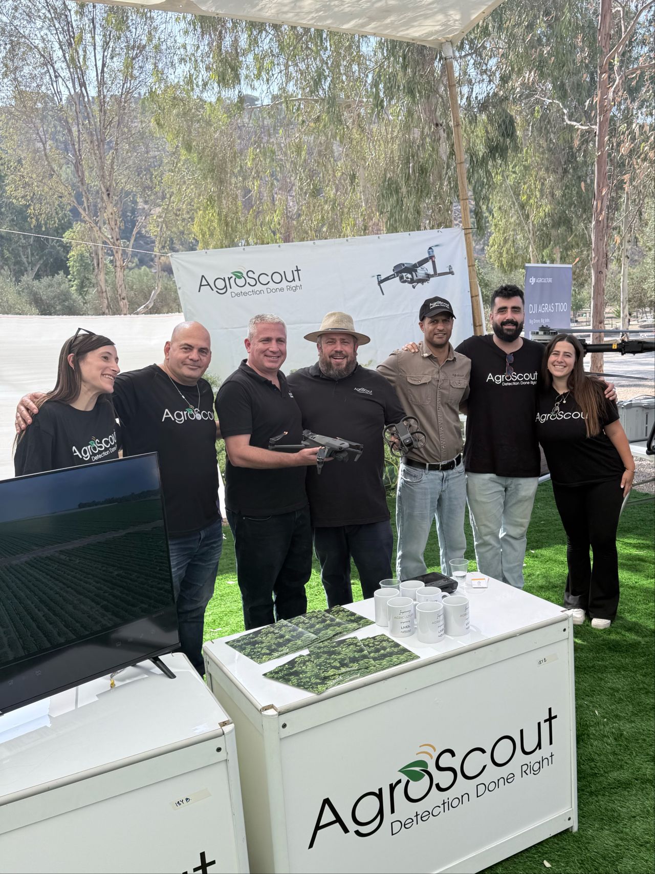 AgroScout team holding DJI drones at an outdoor field demo day