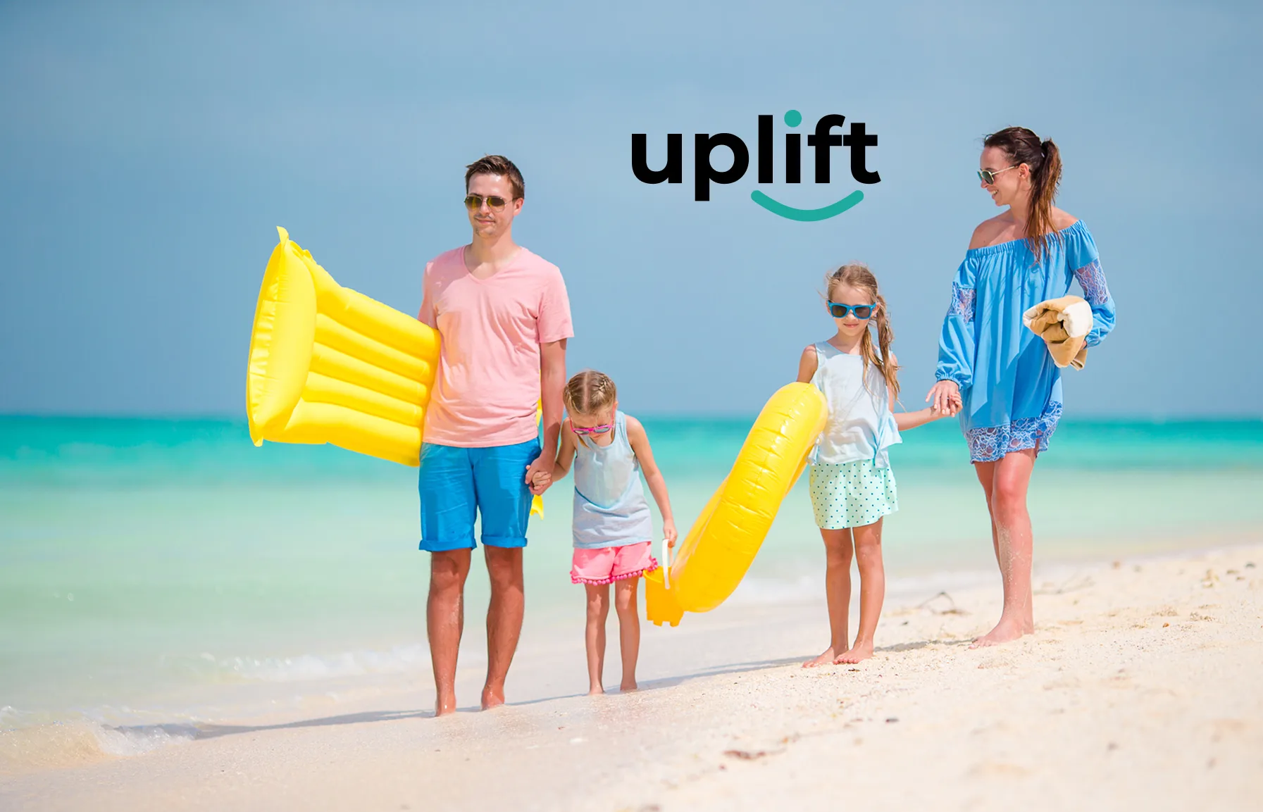 A family of four at the beach having fun and the Uplift logo in the background