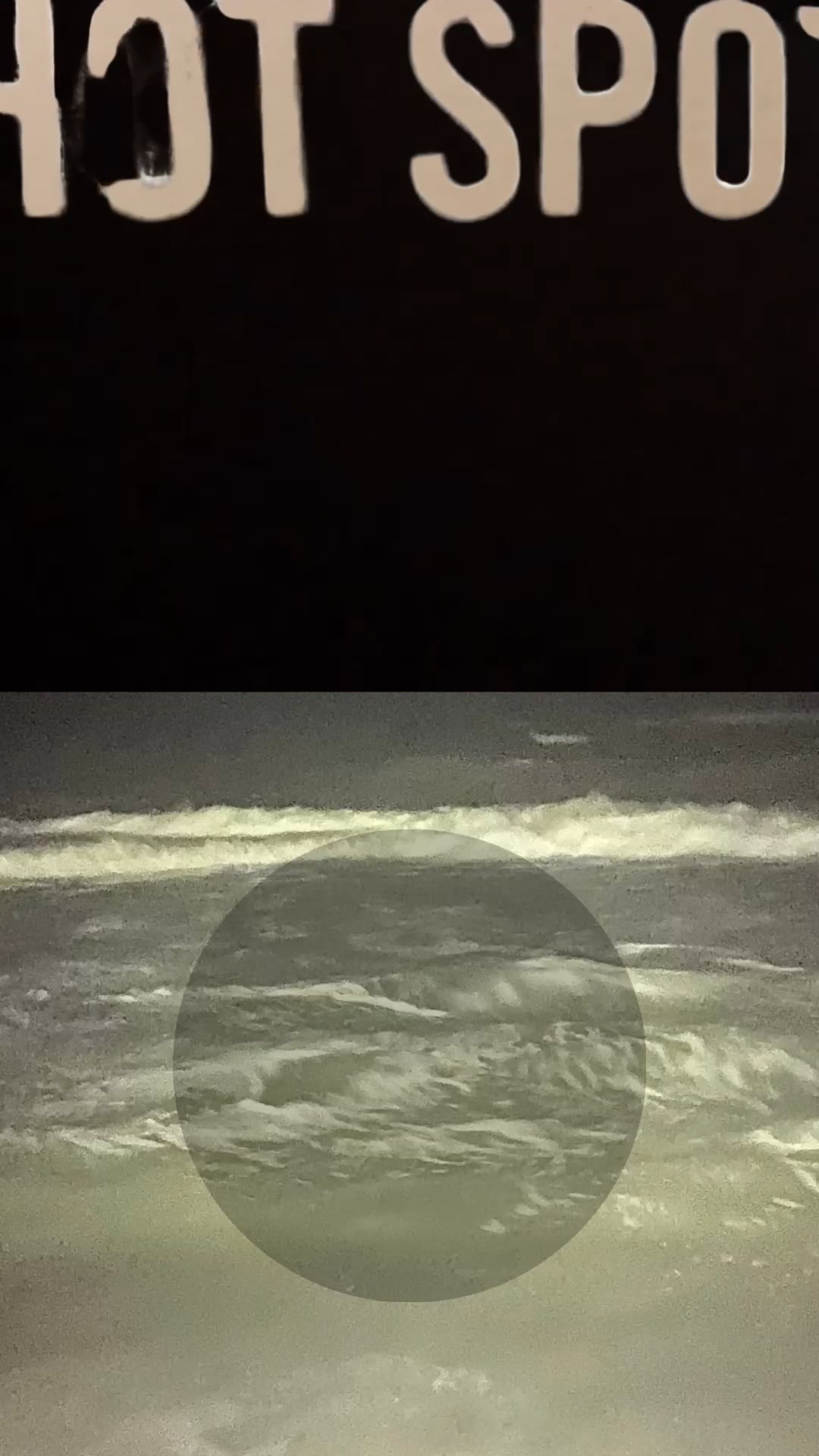 White “HOT SPOT” text above a photo of ocean waves at night with a dark circular overlay.