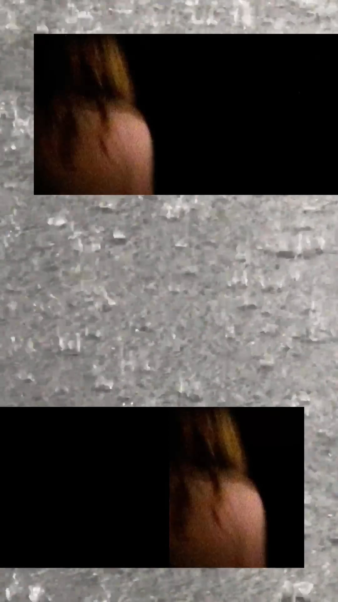 A blurry close-up of a woman’s back framed by static-like gray textures.