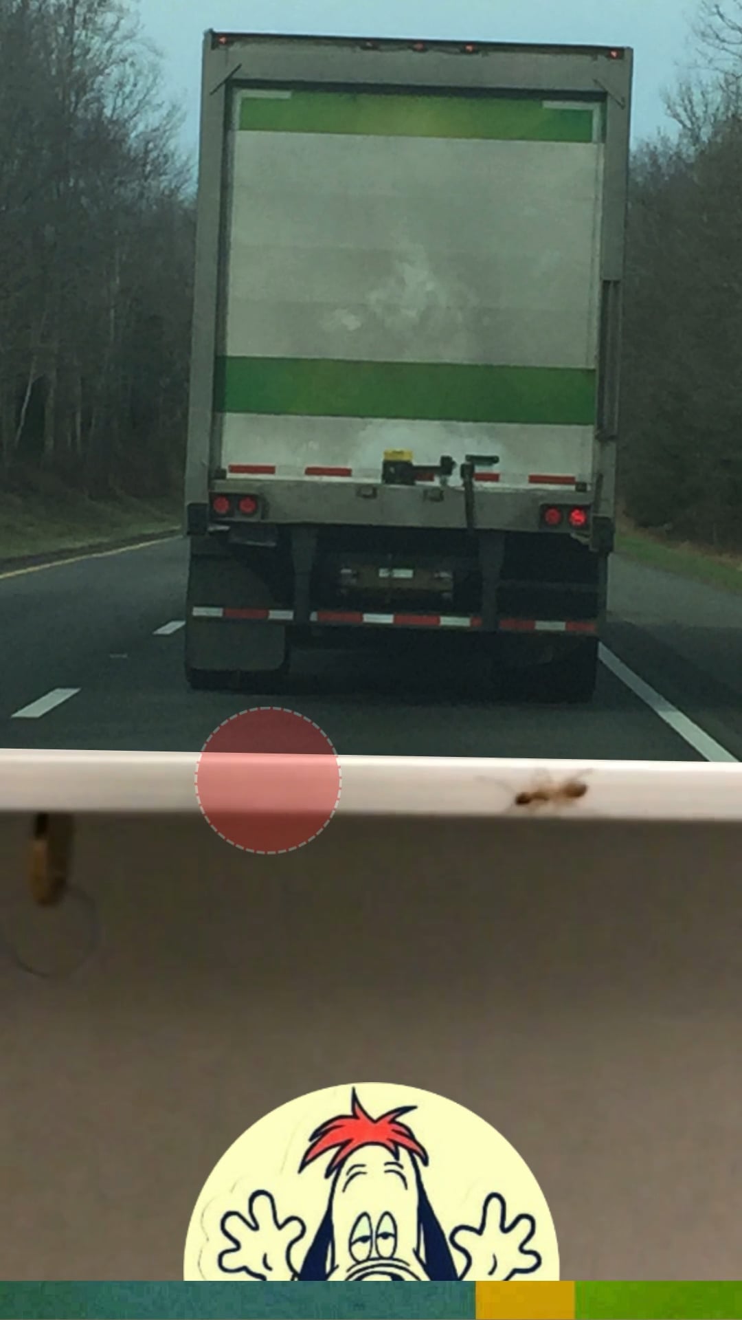 A truck on a highway with an ant on a windowsill and a cartoon dog face below.