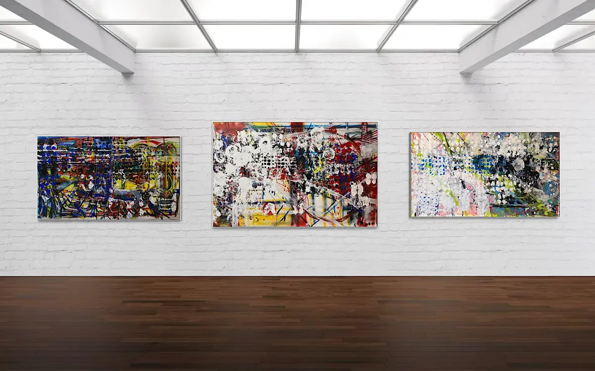 Three abstract paintings hang on a white brick gallery wall, each filled with layered colors and patterns—blue and yellow on the left, red and white in the center, and pale blues and greens on the right.