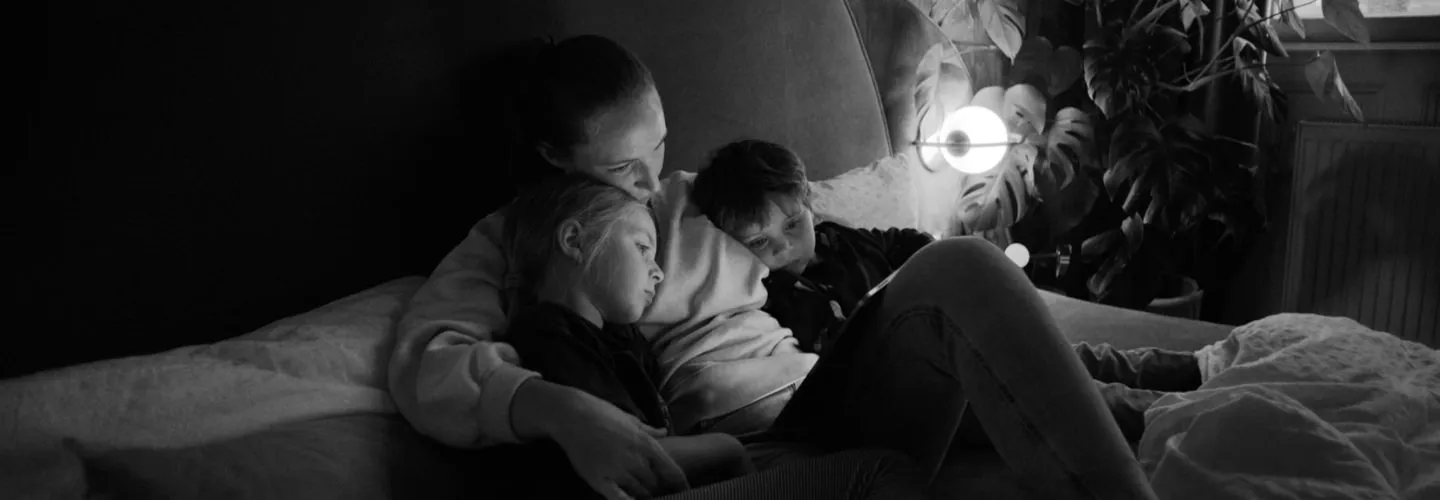 Mother with son and daughter intimate moment in bed