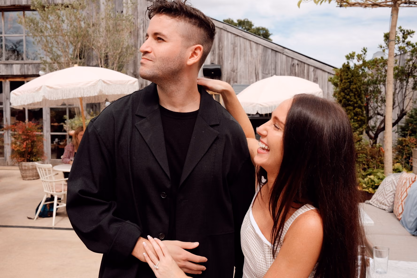 Smiling couple dancing outdoors, the man dipping the woman as they hold hands.