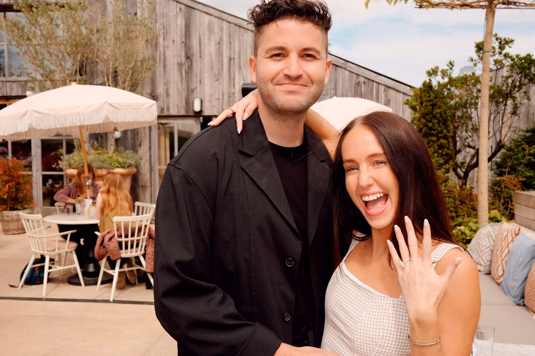 Smiling couple dancing outdoors, with the man dipping the woman as they hold hands.
