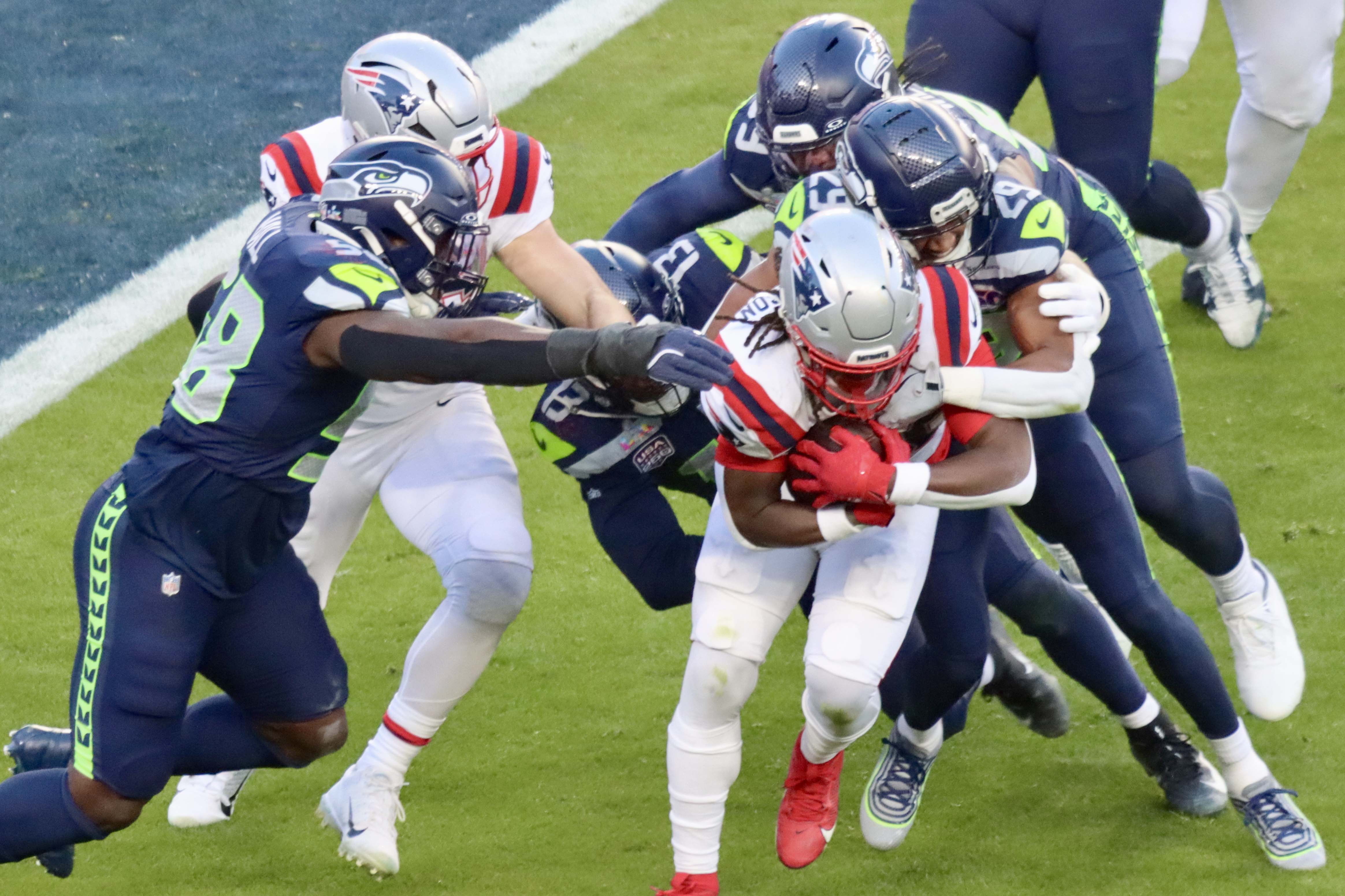 Defense Wins Championship - Patriots Rhamondre Stevenson gets gang tackled by Seahawks.