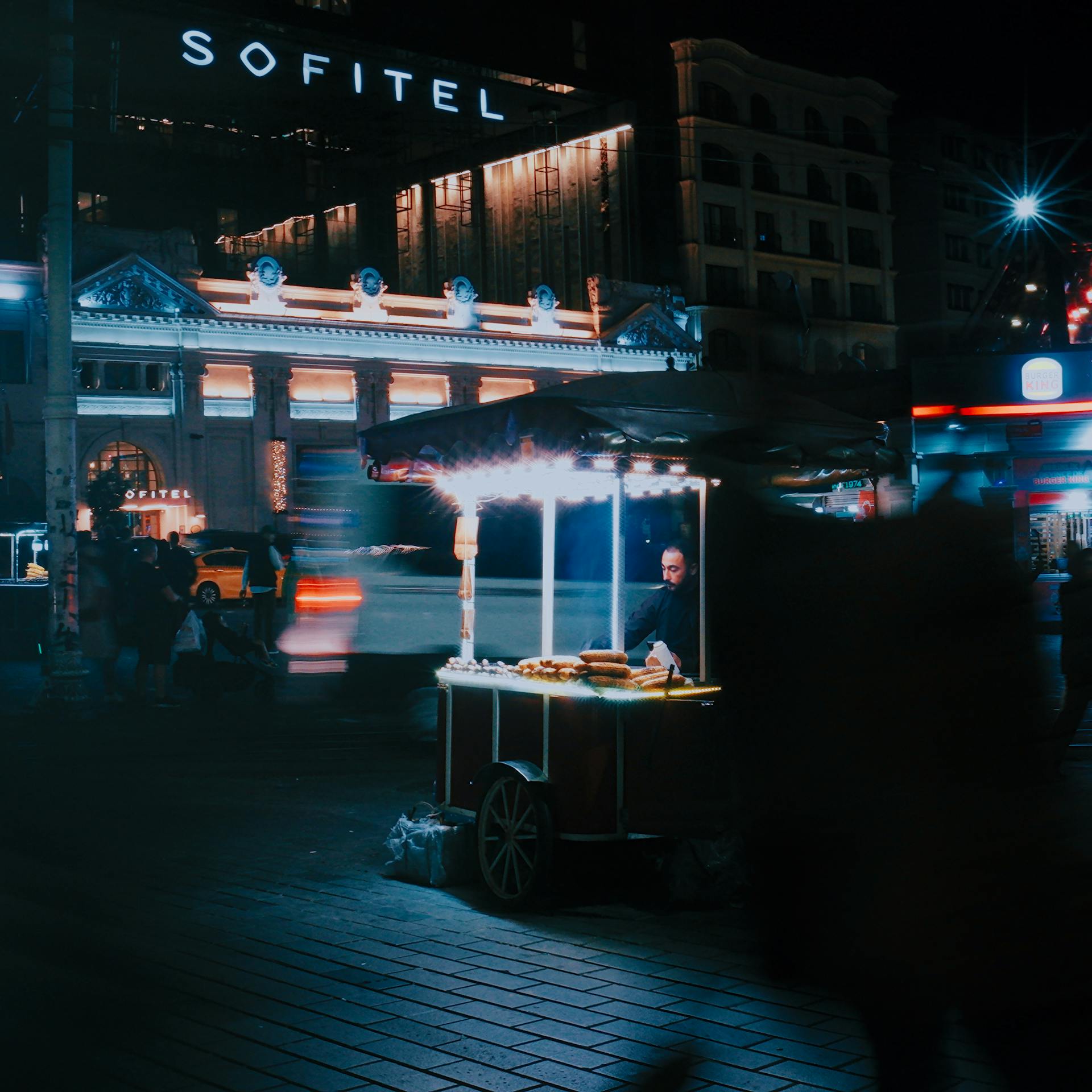Busy urban night scene with a glowing street food cart in Istanbul. Photo by Abdullah Öğük on Pexels.com