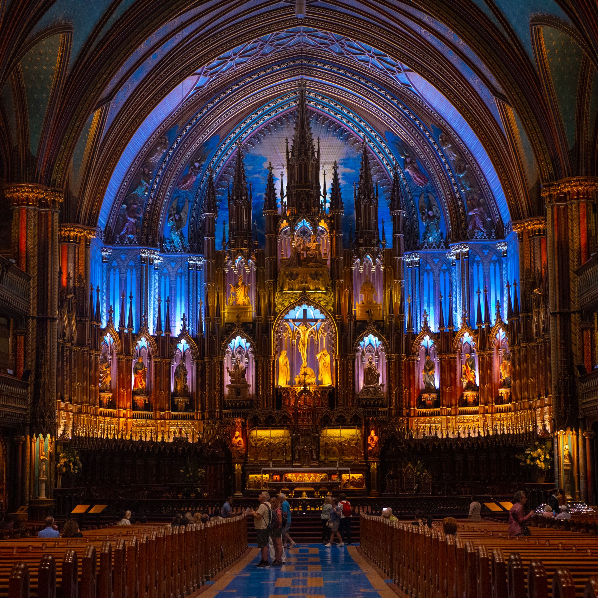 Ornate interior of Notre-Dame Basilica in Montréal with vibrant lighting. Photo by Valentin But via Pexels.com.