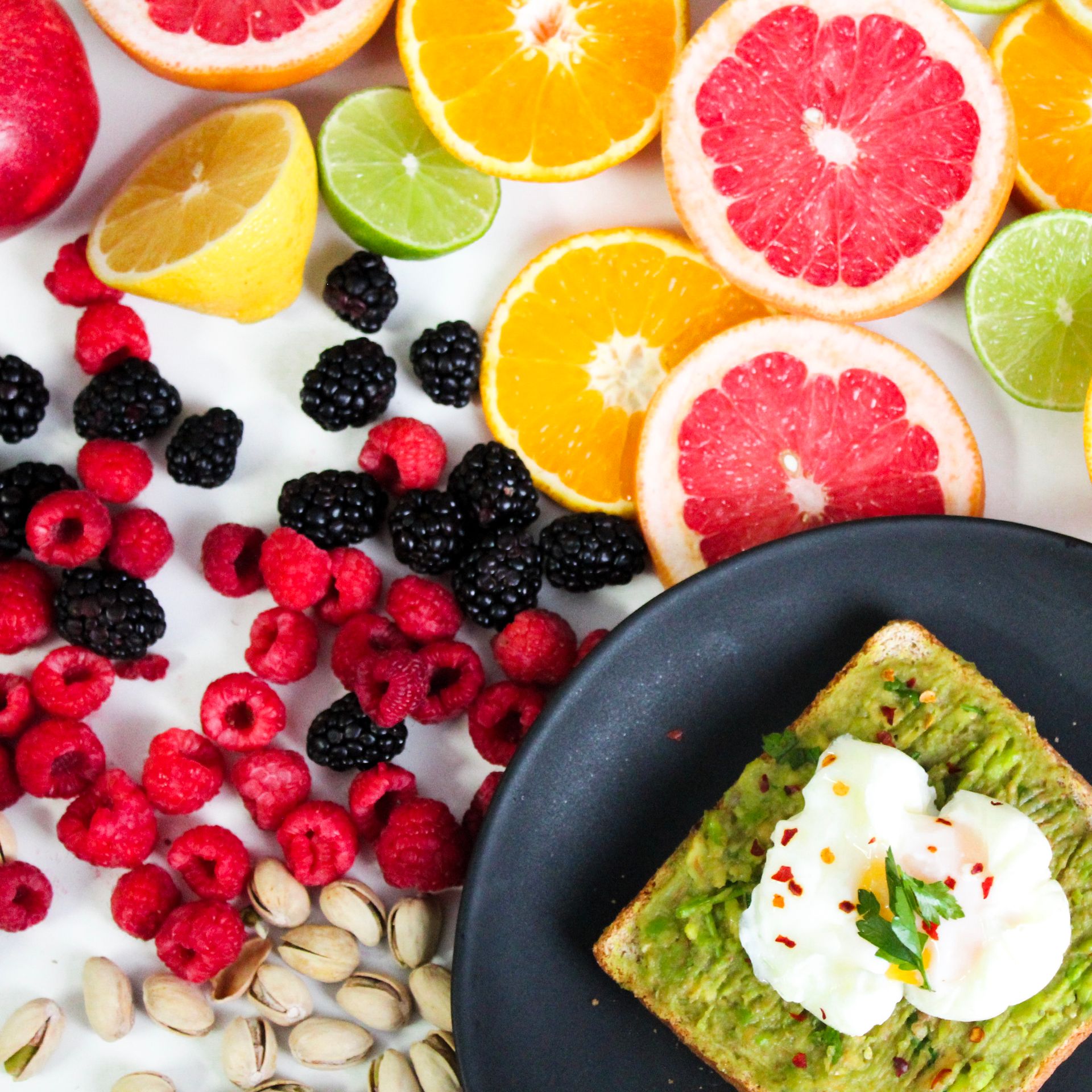 Colorful avocado toast with assorted fresh fruits including citrus, berries, and pistachios. Photo by Jane T D. via Pexels.com