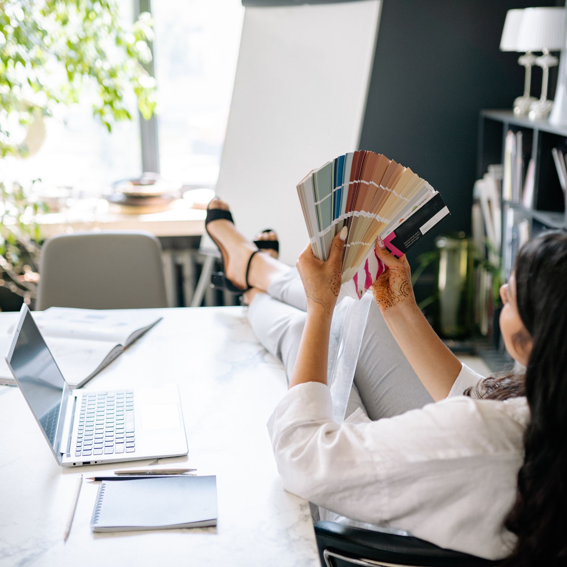 Designer relaxing at desk, exploring color swatches in a modern office setting. Photo by Yan Krukau, via Pexels.com