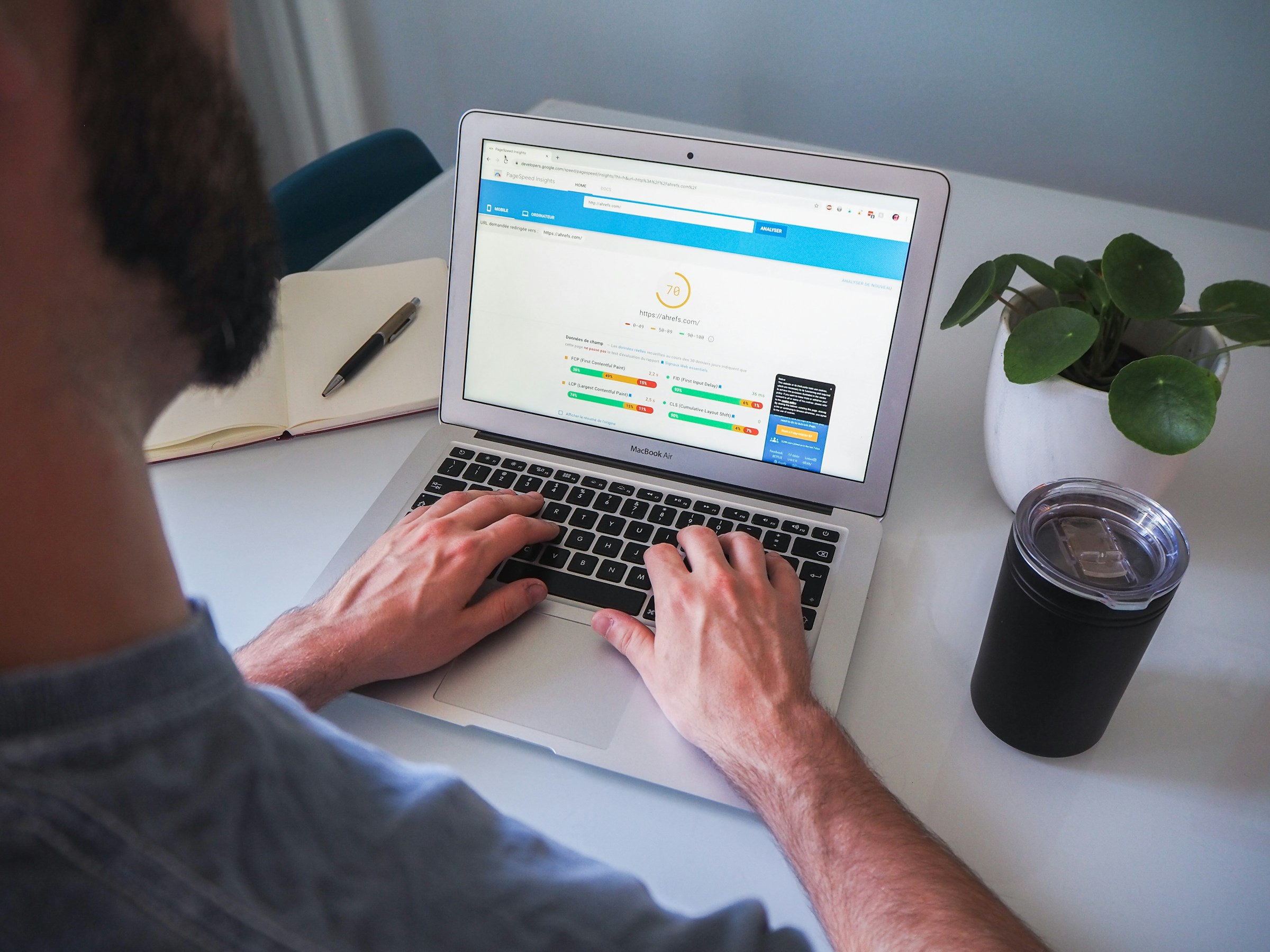 Over-the-shoulder view of man working on a laptop computer