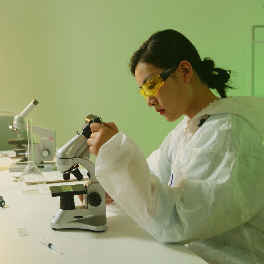 A scientist in a laboratory uses a microscope for research. Indoor lab setting. Photo by Artem Podrez via Pexels.com