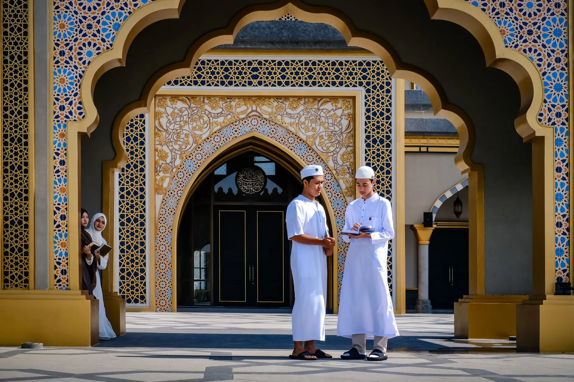 Group of young Muslims engaged in study at a mosque entrance. Photo by Noval Gani via Pexels.com