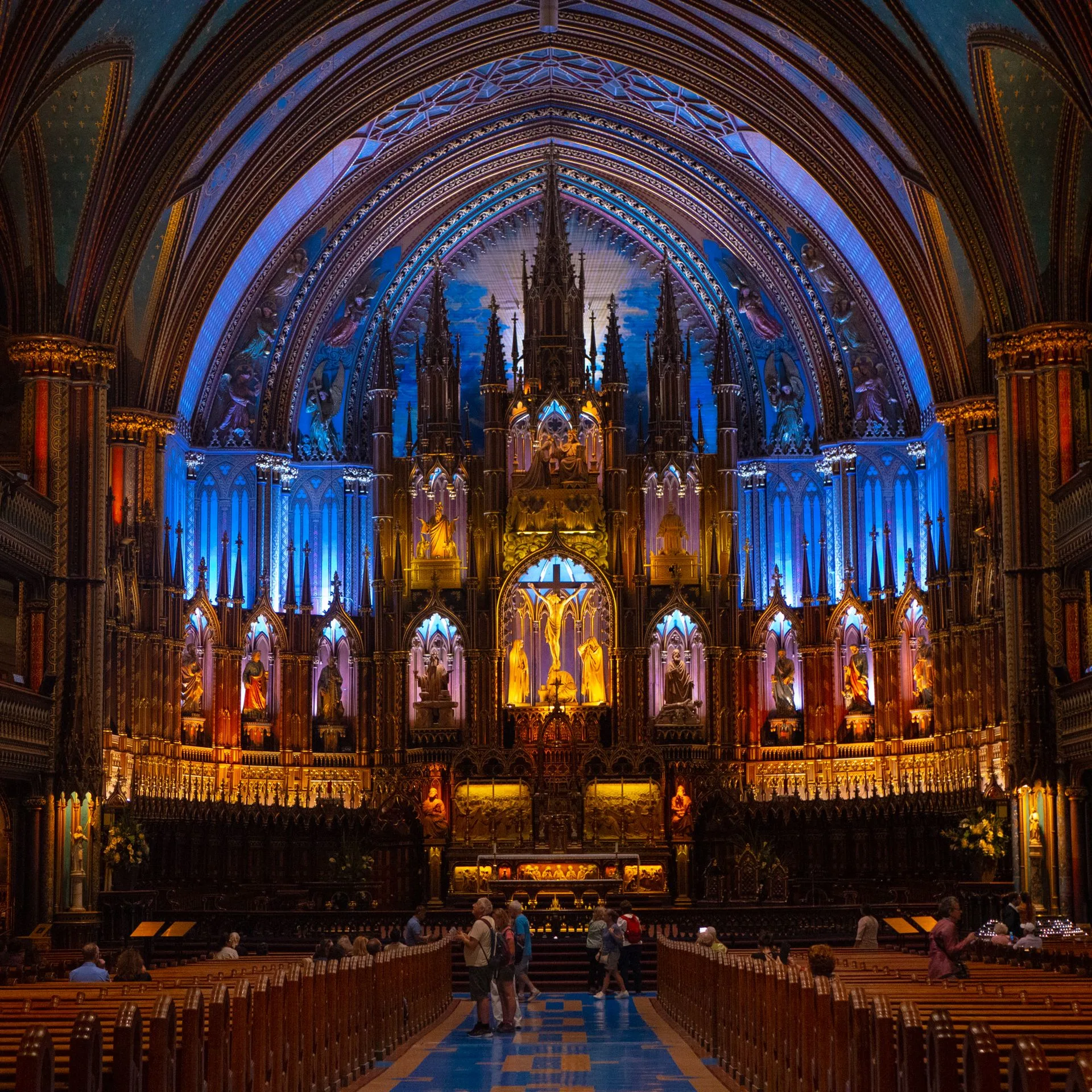 Ornate interior of Notre-Dame Basilica in Montréal with vibrant lighting. Photo by Valentin But via Pexels.com.