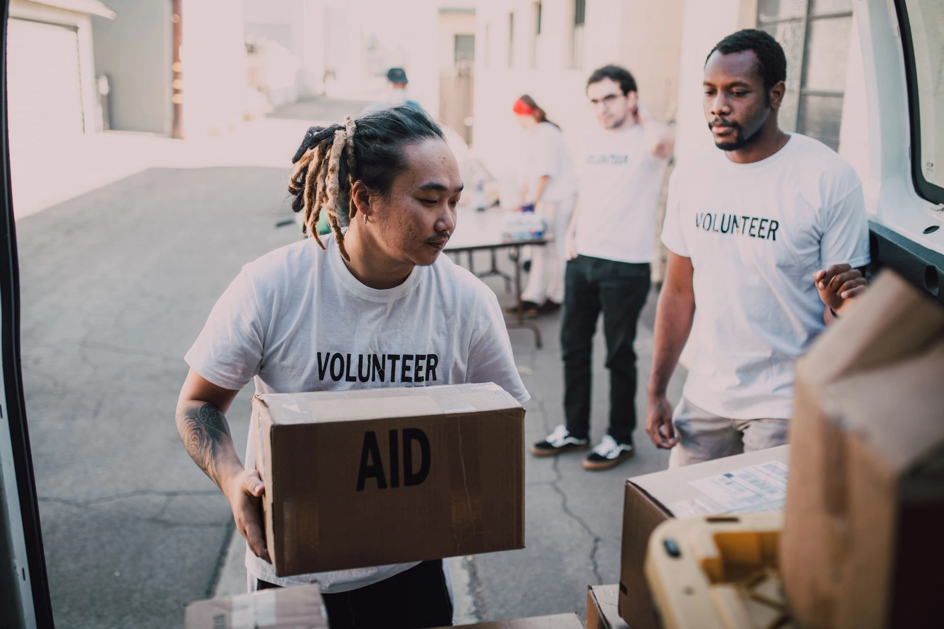 Volunteers unload aid supplies from a van, showcasing teamwork and community support. Photo by RDNE Stock project via Pexels.com