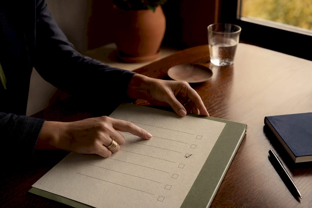 Hands pointing at checklist item in financial planning