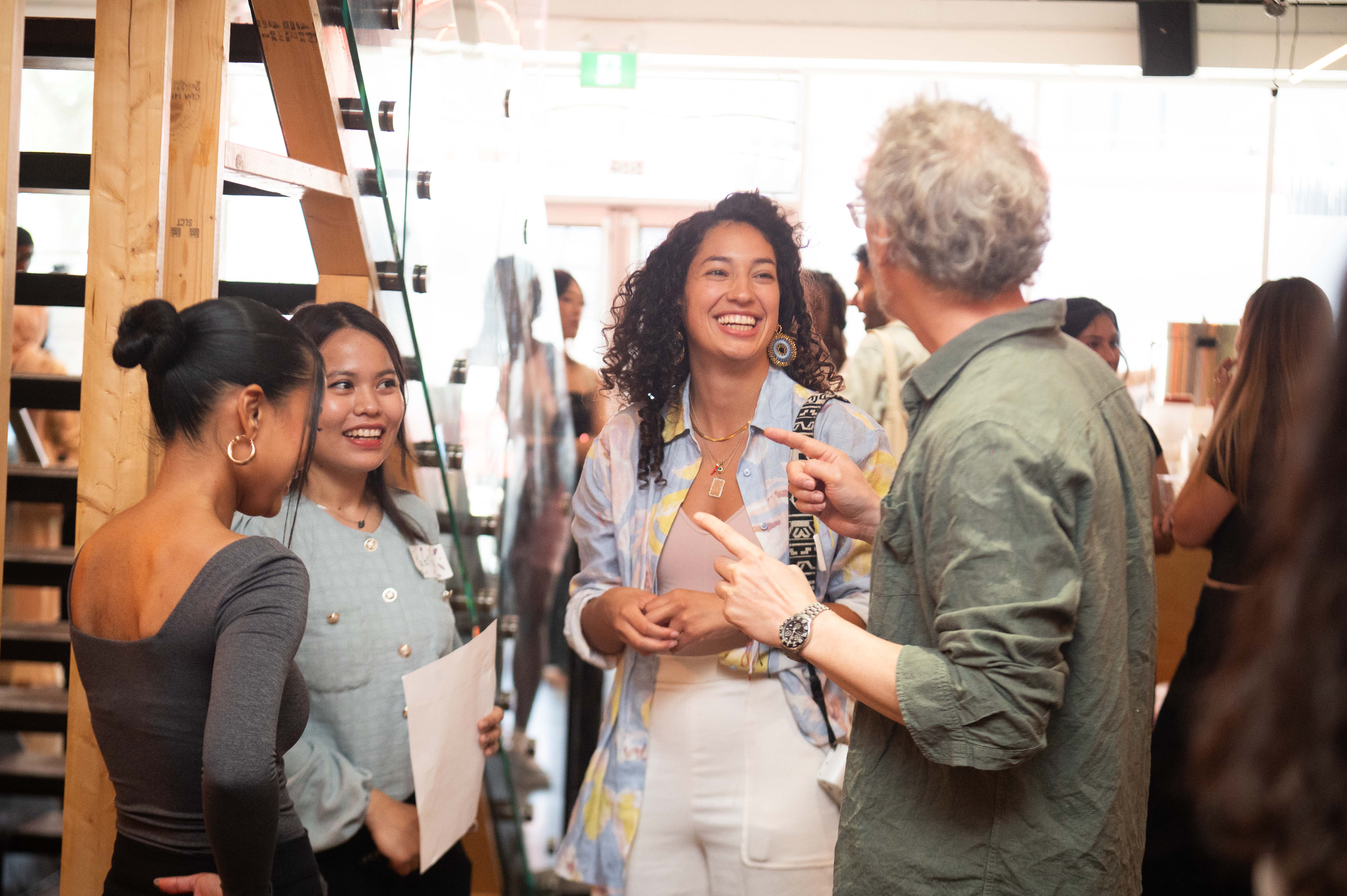 People sitting around a table, networking and chatting over coffee.