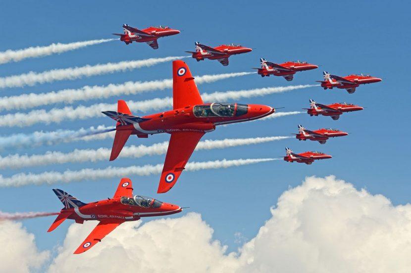 A group of red jets flying in formationAI-generated content may be incorrect.
